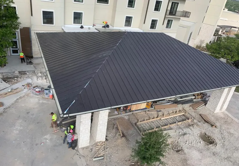Metal roofing installation team working on a commercial building in Eastham